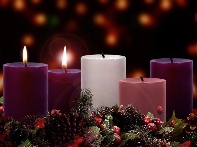 A photograph of three purple candles, one pink candle, and a white candle. Two of the purple candles are lit.